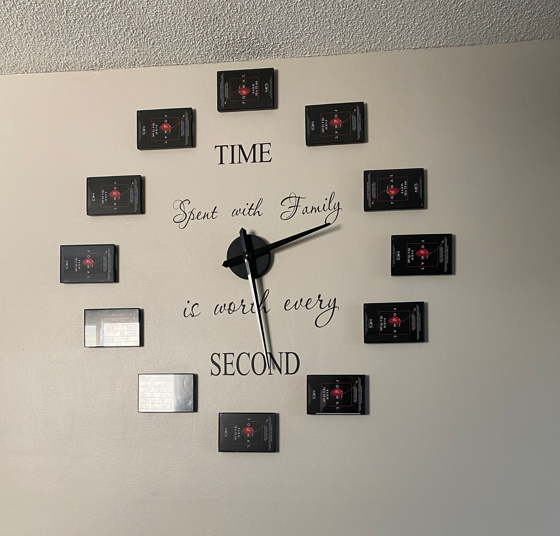 Wall clock with quote 'Time spent with family is worth every second' and black rectangular markers.